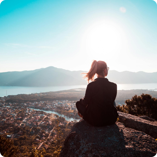 Woman sitting down looking into the mountains in the distance